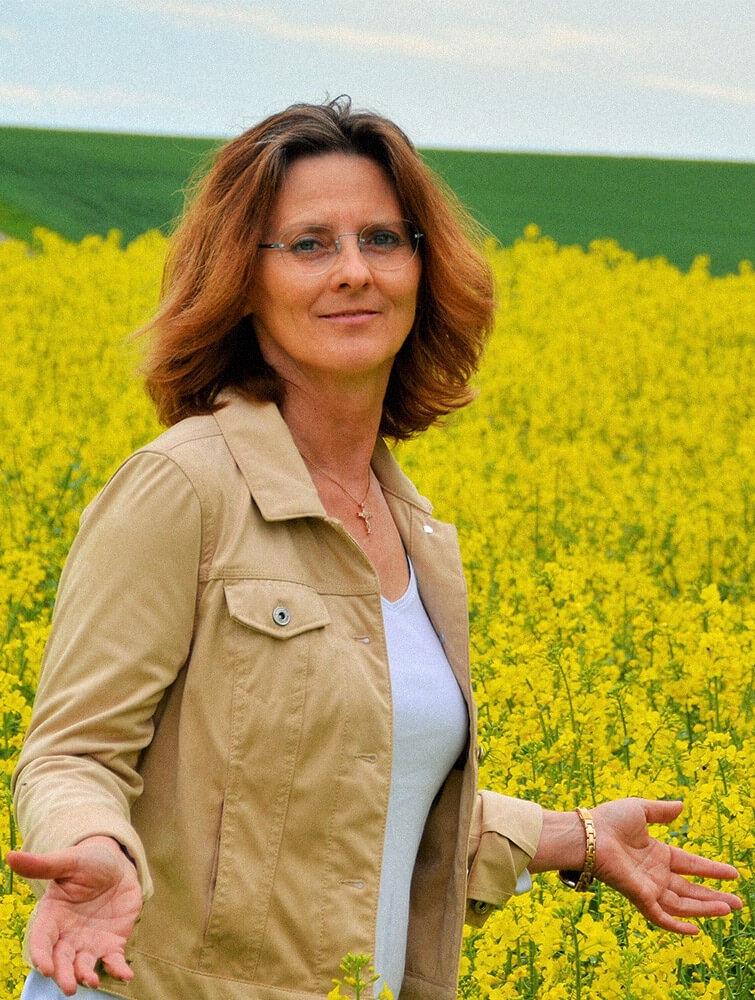 Dagmar Wirth an einem sonnigen Tag inmitten eines Rapsfeldes